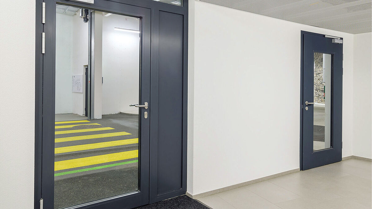 Optisch kaum zu unterscheiden: Alu-Glas-Portale und Stahltüren mit grösstmöglichem Glasausschnitt und hochwertig pulverbeschichteter Oberfläche.